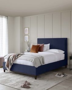 a bedroom with white walls and teal colored bedding on the bottom level, along with an area rug that has been placed on the floor