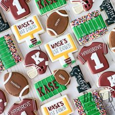 decorated cookies are arranged on a table for a football themed birthday party, with the number one