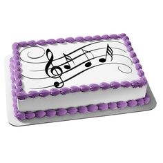 a sheet cake with purple icing and musical notes on it's side, sitting on a white surface