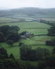 an aerial view of a house in the middle of a field with sheep grazing on it