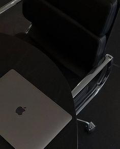 an apple laptop sitting on top of a black table