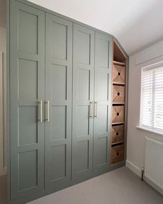 an empty room with green cabinets and drawers in the corner, next to a radiator