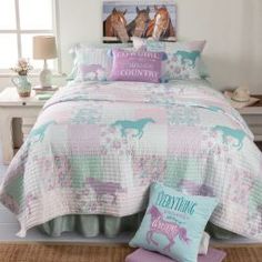 a bed with pink and blue comforters in a bedroom