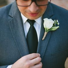 a man wearing a suit and tie with a boutonniere on his lapel