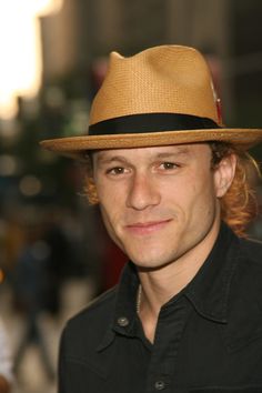 a man wearing a brown hat and black shirt