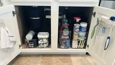 an open cabinet in the middle of a kitchen with cleaning products and other items inside