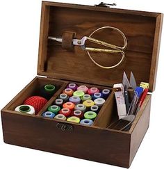 an open wooden box filled with lots of crafting supplies