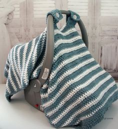 a blue and white crocheted blanket sitting on top of a car seat cover