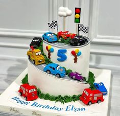 a birthday cake with cars on it and the number five is made out of fondant