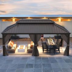 a covered patio with chairs and tables in the evening