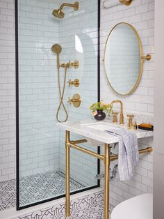 a bathroom with white tile and gold fixtures