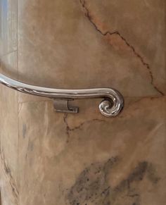 a close up of a metal handle on a marble wall