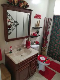 a bathroom decorated for christmas with red accessories