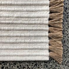 a white rug with brown fringes on top of it