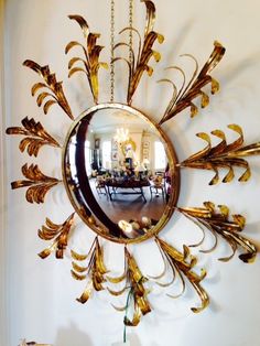 a mirror that is hanging on the wall next to a vase with flowers in it