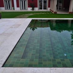 an empty swimming pool in front of a house