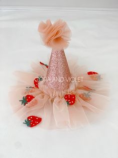 a pink party hat with strawberries on it