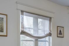 a window with a white curtain hanging from it's side