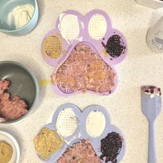 dog paw shaped cookie cutters are on the counter next to bowls and utensils