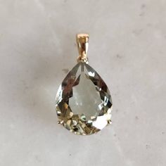 ITEM DESCRIPTION: >>The pendant is made from Solid 14K Yellow Gold. Gemstone used is absolutely natural and ethically sourced. >>Natural Green Amethyst in emerald cut and pear shape with prong setting is studded on it with utmost precision. >>This is a minimalist design and is absolutely hassle-free and everyday jewelry. Gem: Green Amethyst Gem size: 12x16 mm pear Gem weight: 7.95 carats Gold purity: 14K (58.33% approx.) Gold weight: 0.95 grams Gross weight: 2.54 grams The Gold purity is guarant Oval Green Amethyst Jewelry In Yellow Gold, 14k Yellow Gold Jewelry With Large Stone, Yellow Gold Green Amethyst Gemstone Jewelry, Elegant Gold Gemstones With Large Stone, Fine Jewelry Green Amethyst Gemstones For Gifts, Yellow Gold Drop Gemstones For Gift, Fine Jewelry Gold Drop Gemstones, Yellow Gold Green Amethyst Jewelry For Wedding, Handmade Jewelry Box