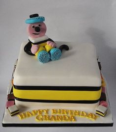 a birthday cake with a teddy bear on top