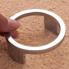 a hand is touching a ring on the ground