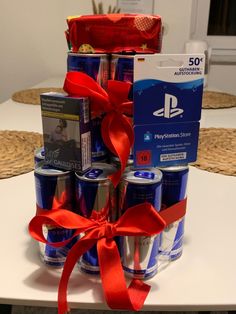 a large stack of soda cans with red ribbon