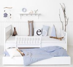 a white day bed with pillows and blankets on it