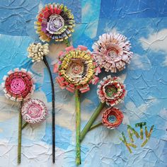 three flowers made out of rolled up paper