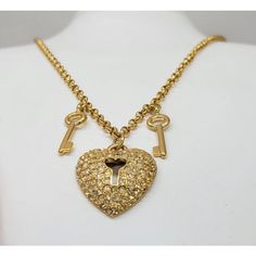 1980s goldtone pave round clear rhinestone heart with lock cut out center pendant with two goldtone key charms on either side necklace with lobster clasp. Marked "Napier" in script on a cartouche near the clasp and "©Napier" in script on the back of the pendant. Heart pendant measures: 1 1/8 inches long by 1 inch wide. Chain doubled measures: 15 1/4 inches long. Condition: Very good; perhaps a little bit of yellowing to a few rhinestones but nothing very noticeable. Gold Heart Necklace With Two Keys, Key Charms, Lock Pendant, Pendant Heart, Heart Lock, Rhinestone Heart, Clear Rhinestones, Vintage Signs, Heart Pendant