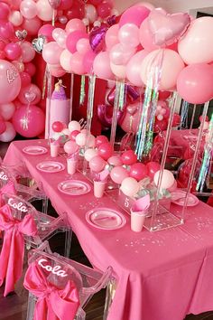 the table is set with pink and white balloons