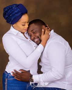 a man and woman hugging each other in front of a brown background