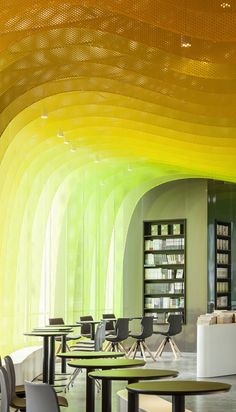 the interior of a library with tables, chairs and bookshelves