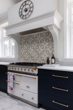 a white and black kitchen with gold trimmings on the oven, counter tops and cabinets