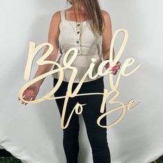 a woman standing in front of a white backdrop with the words bride to be written on it