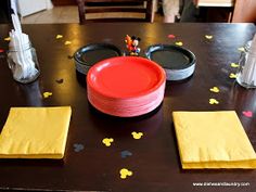 mickey mouse plates and napkins on a table