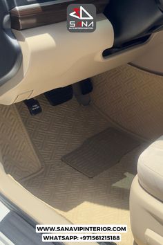 the interior of a car with beige carpet and black leather trims, showing the floor mats