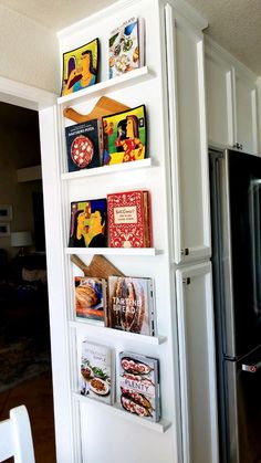 a refrigerator and shelves in a kitchen with magnets on the wall next to it