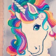 a cake shaped like a unicorn with multicolored hair on it's head