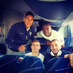 four men posing for a photo in the back of an airplane