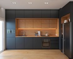 an empty kitchen with wooden cabinets and stainless steel appliances, along with wood flooring