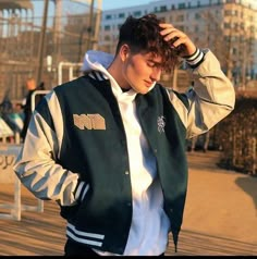 a young man wearing a green and white jacket