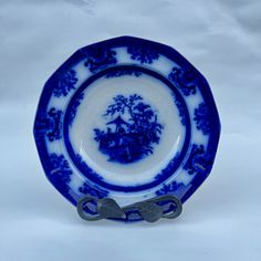 a blue and white plate with scissors on the edge that is sitting on a table