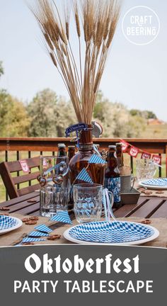 the oktoberfest party table is set with blue and white plates, beer bottles, and wheat stalks