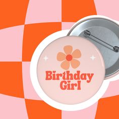 a pink button with the words birthday girl on it and a flower in the center