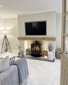 a living room with a couch, fireplace and television on the wall in it's corner