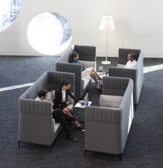 four people sitting on couches in an office setting