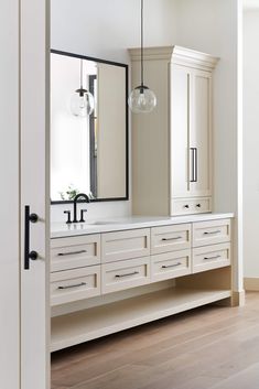 a white bathroom with two sinks and large mirrors