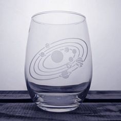 a clear glass with an alien design on the bottom and some bubbles in the middle