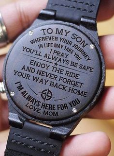 a person holding a wooden watch with the words to my son on it's face